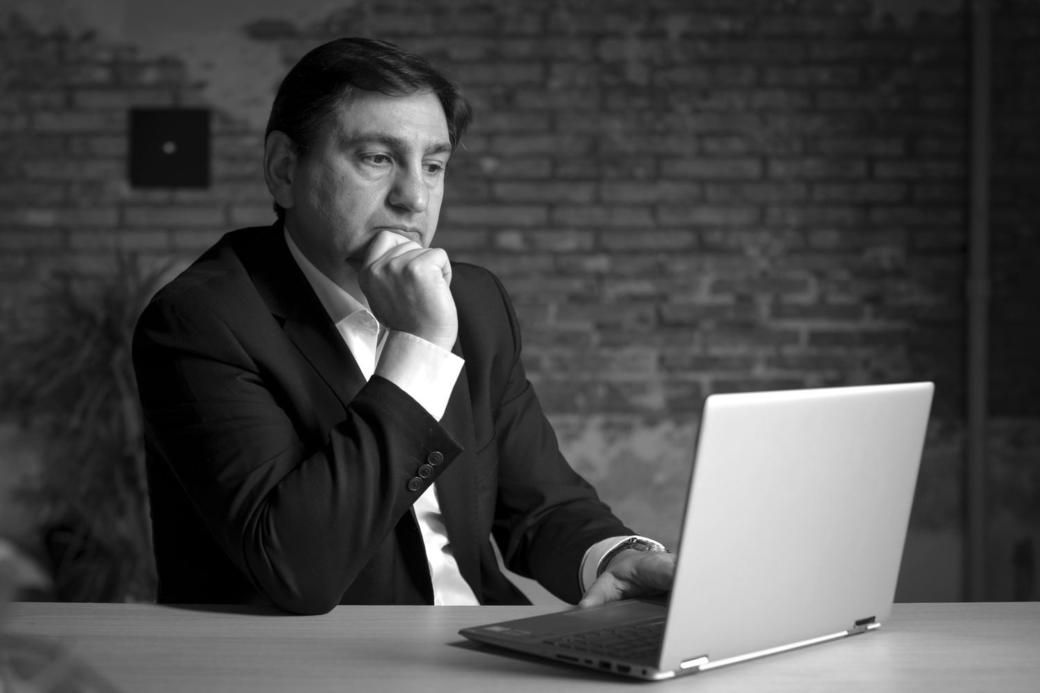 Javier Iborra, pensativo, ante un ordenador portátil.
